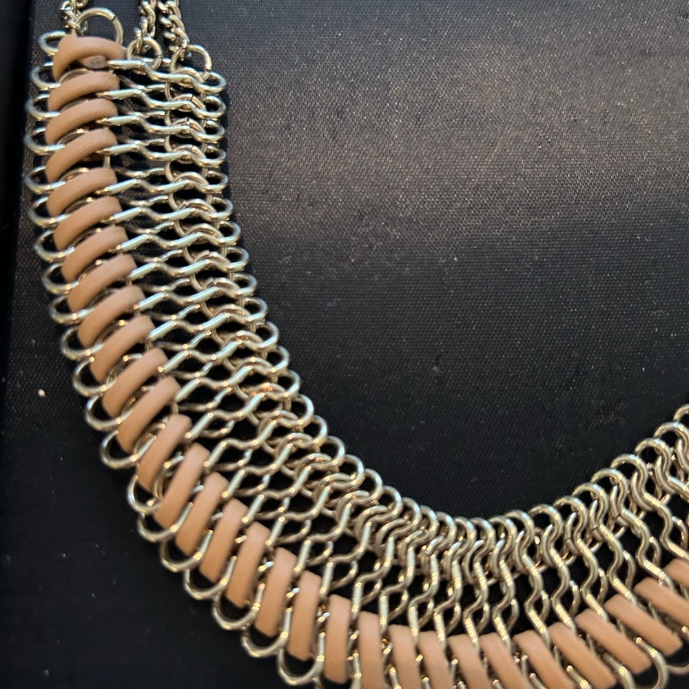Gd tone necklace with a natural leather intertwined In necklace.